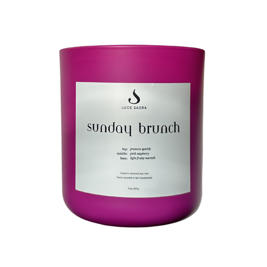 Fuscia candle labeled 'Sunday Brunch' by Luce Sacra on a white background
