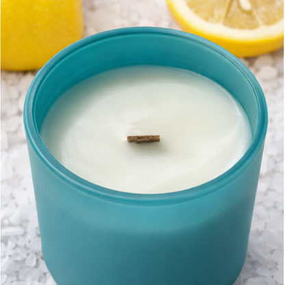 Blue 'sea salt' candle with lemons on a white background